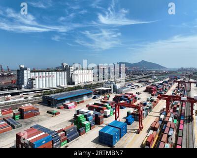 LIANYUNGANG, CHINA - 14. SEPTEMBER 2023 - Großmaschinen laden Container in China-Europa Güterzug bei der China-Kasachstan (Lianyungang) Logistik Stockfoto