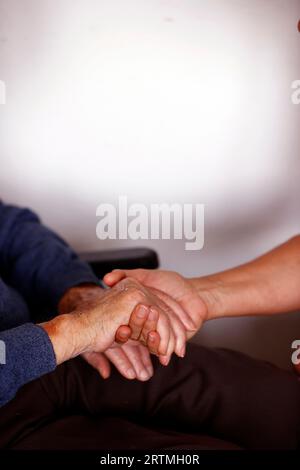 Abmeldung nach Hause. Nahaufnahme von Pflegekräften, die den älteren Mann beruhigen. Stockfoto