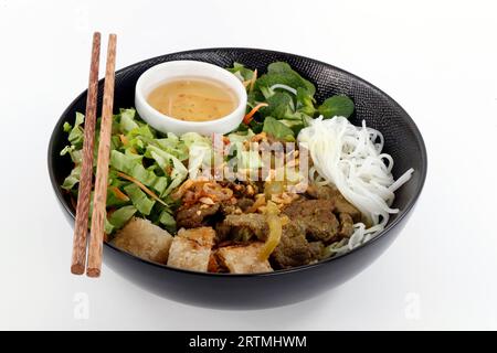 Asiatische Küche. Vietnamesische Küche. Schüssel Rindfleisch Bo Bun mit Salat, Rindfleisch und frischen Kräutern. Stockfoto