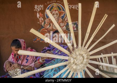 Adivasi-Frauen, die Körbe in einem Dorf im Bezirk Narmada, Gujarat, Indien, herstellen Stockfoto