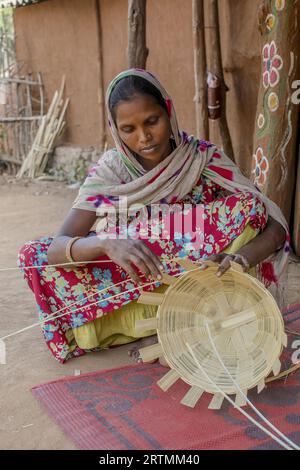 Adivasi-Frau, die Körbe in einem Dorf im Bezirk Narmada, Gujarat, Indien, herstellt Stockfoto