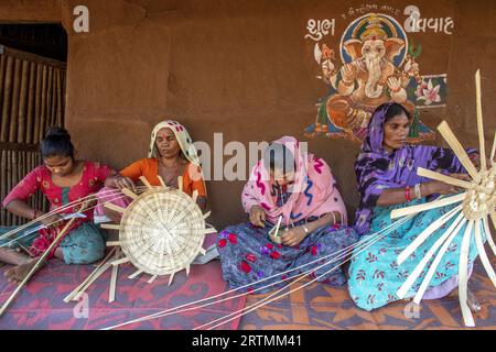 Adivasi-Frauen, die Körbe in einem Dorf im Bezirk Narmada, Gujarat, Indien, herstellen Stockfoto