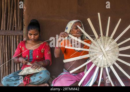 Adivasi-Frauen, die Körbe in einem Dorf im Bezirk Narmada, Gujarat, Indien, herstellen Stockfoto