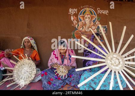 Adivasi-Frauen, die Körbe in einem Dorf im Bezirk Narmada, Gujarat, Indien, herstellen Stockfoto