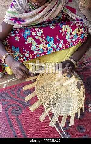 Adivasi-Frau, die Körbe in einem Dorf im Bezirk Narmada, Gujarat, Indien, herstellt Stockfoto