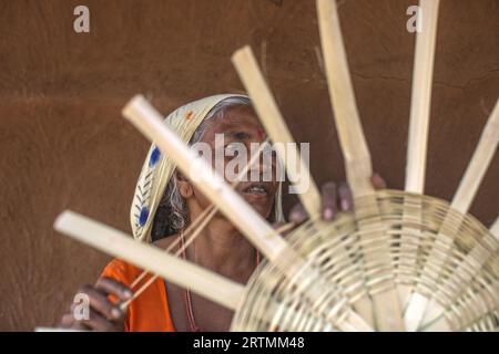 Adivasi-Frau, die Körbe in einem Dorf im Bezirk Narmada, Gujarat, Indien, herstellt Stockfoto