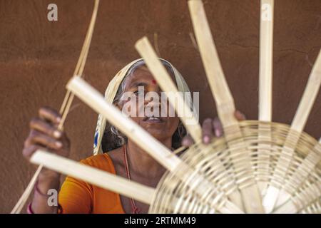 Adivasi-Frau, die Körbe in einem Dorf im Bezirk Narmada, Gujarat, Indien, herstellt Stockfoto