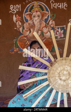 Adivasi-Frau, die Körbe in einem Dorf im Bezirk Narmada, Gujarat, Indien, herstellt Stockfoto