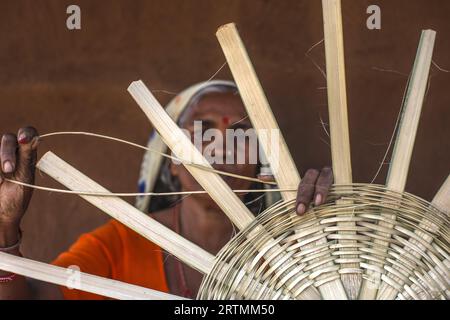 Adivasi-Frau, die Körbe in einem Dorf im Bezirk Narmada, Gujarat, Indien, herstellt Stockfoto