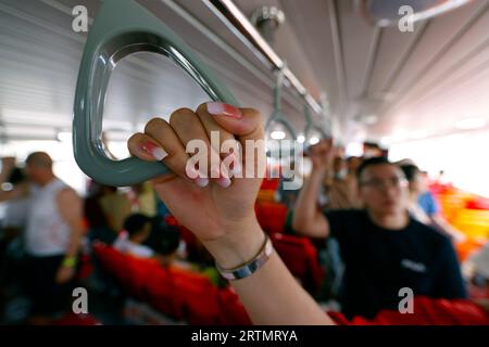 Personen in Chao Praya Express Boat Bangkok, öffentliches Boot, Fähre. Halten Sie den Griff mit der Hand. Bangkok. Thailand. Stockfoto