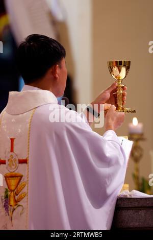 St. Nikolaus Kathedrale Dalat. Sonntagsmesse. Rückansicht des Priesters mit keule bei der eucharistiefeier. Dalat. Vietnam. Stockfoto