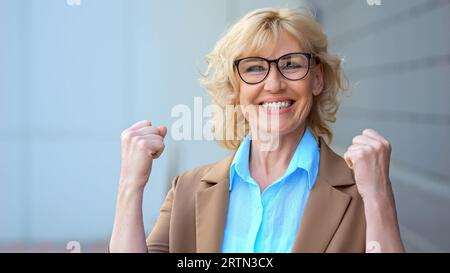 Eine freudige Geschäftsfrau freut sich über gute Nachrichten über Arbeit Stockfoto