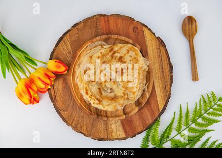 Malabar parota im isolierten Hintergrund. Südindische Porata in einem Holzteller und dekoriert und isoliert. Auch als Nool porata, Roti Parata oder Ro bezeichnet Stockfoto