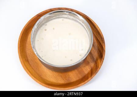 Selektiv fokussiertes Bild von fermentiertem Teig für Idli und Dosa im isolierten Hintergrund. Idly und Dosa-Teig in einer Schüssel zur Gärung. Stockfoto