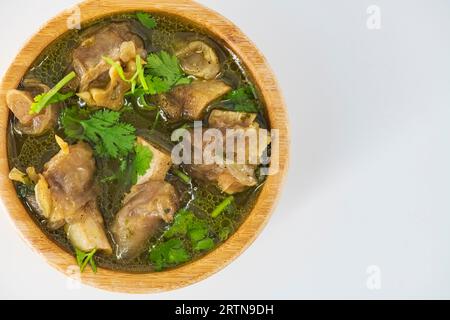 Frisch gewürzte Lammsuppe in einer Holzschüssel, verzehrfertig. Hausgemachte Hammelsuppe namens paya oder attukaal Suppe in südindien. Hammelsuppe aus Holz Stockfoto