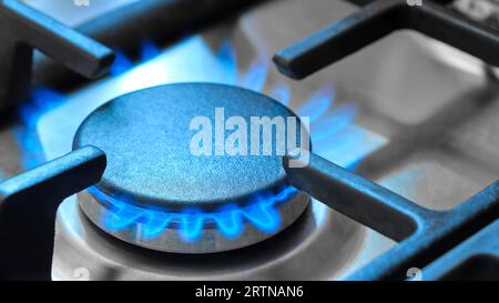 Nahaufnahme der blauen Flammen aus einem Gasherd in einer Küche. Gasherd mit brennenden Flammen von Erdgas. Konzept fossiler Brennstoffe und nicht erneuerbarer Energieträger Stockfoto