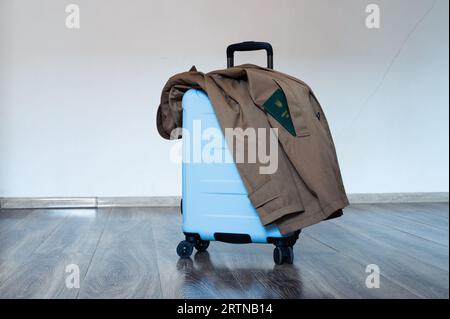 Übersetzung: "Militärische ID". Reisetasche mit offenem Griff und Kleiderständer auf dem Boden. In der Tasche befindet sich ein Dokument Stockfoto