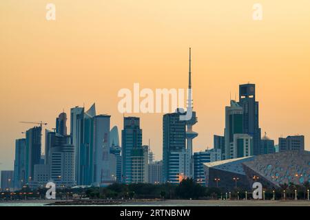 Blick auf die Skyline von Kuwait - mit dem bekanntesten Wahrzeichen von Kuwait City - bei Sonnenuntergang. Kuwait City Gebäude und Skyline vom Strand Stockfoto