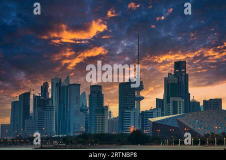 Blick auf die Skyline von Kuwait - mit dem bekanntesten Wahrzeichen von Kuwait City - bei Sonnenuntergang. Kuwait City Gebäude und Skyline vom Strand Stockfoto