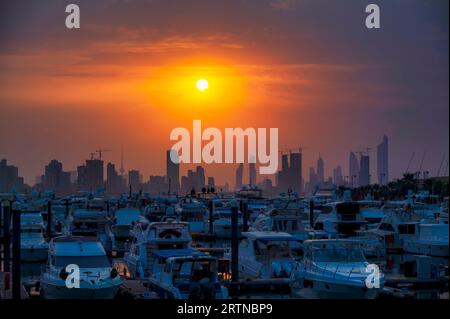 Blick auf die Skyline von Kuwait - mit dem bekanntesten Wahrzeichen von Kuwait City - bei Sonnenuntergang. Kuwait City Gebäude und Skyline vom Strand Stockfoto