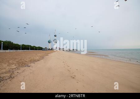 Blick auf die Skyline von Kuwait - mit dem bekanntesten Wahrzeichen von Kuwait City - bei Sonnenuntergang. Kuwait City Gebäude und Skyline vom Strand Stockfoto