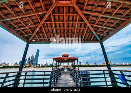Blick auf die Skyline von Kuwait - mit dem bekanntesten Wahrzeichen von Kuwait City - bei Sonnenuntergang. Kuwait City Gebäude und Skyline vom Strand Stockfoto