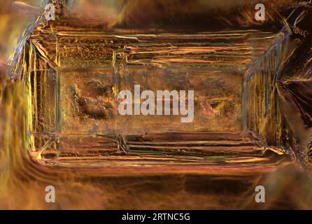 Das Bild zeigt einen einzelnen Kristall aus rekristallisiertem Kochsalz, der durch das Mikroskop in polarisiertem Licht mit einer Vergrößerung von 200X aufgenommen wurde Stockfoto