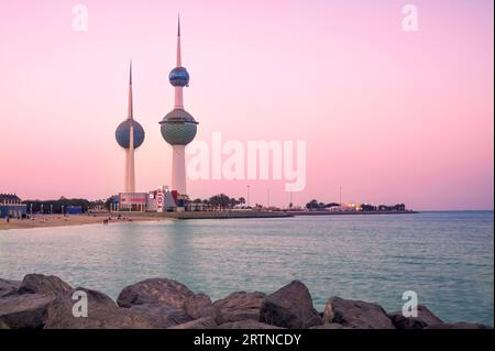 Blick auf die Skyline von Kuwait - mit dem bekanntesten Wahrzeichen von Kuwait City - bei Sonnenuntergang Stockfoto