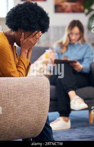 Psychische Gesundheit, Stress und Psychologie mit einer schwarzen Frau in der Therapie, im Gespräch mit einem Profi. Angstzustände, Depressionen oder Unterstützung bei einem jungen Patienten Stockfoto