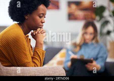 Psychische Gesundheit, Depressionen und Psychologie mit einer schwarzen Frau in der Therapie, im Gespräch mit einem Profi. Angst, Stress oder Unterstützung bei einem jungen Patienten in Stockfoto