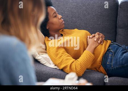 Angst, Depression und Psychologie bei einer schwarzen Frau in Therapie, im Gespräch mit einem Profi. Psychische Gesundheit, Stress oder Unterstützung mit einem jungen Patienten in Stockfoto