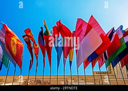 Flaggen verschiedener Länder Europas, Asiens und der USA auf einem Gebäude in Wien vor dem blauen Himmel Stockfoto