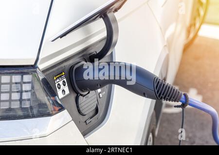 Stuttgart, Deutschland - 10. April 2023: Laden der Batterie eines Elektroautos mit Strom-E-Car an einer elektrischen Tankstellenpumpe in Stuttgart, Keim Stockfoto