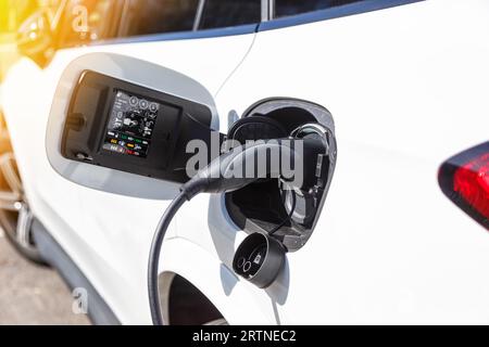 Stuttgart, Deutschland - 10. April 2023: Laden der Batterie eines Elektroautos mit Strom-E-Car an einer elektrischen Tankstellenpumpe in Stuttgart, Keim Stockfoto