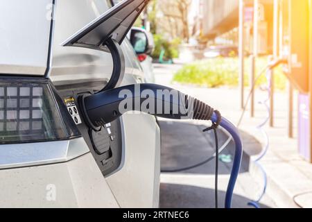 Stuttgart, Deutschland - 10. April 2023: Laden der Batterie eines Elektroautos mit Strom-E-Car an einer elektrischen Tankstellenpumpe in Stuttgart, Keim Stockfoto