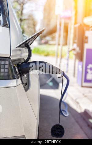 Stuttgart, Deutschland - 10. April 2023: Laden der Batterie eines Elektroautos mit Strom E-Car an einer elektrischen Tankstelle Benzinpumpe Portrait Fo Stockfoto