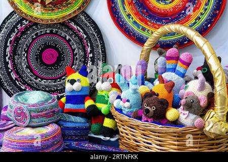 Buntes gestricktes, handgemachtes Kinderspielzeug im Korb. Selbstgemachte Handarbeiten und Stickereien. Stockfoto