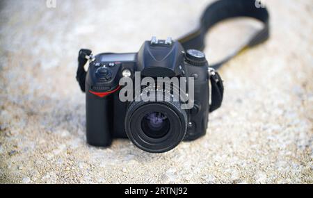 Schwarze DSLR-Kamera auf weißem Sand. Stockfoto