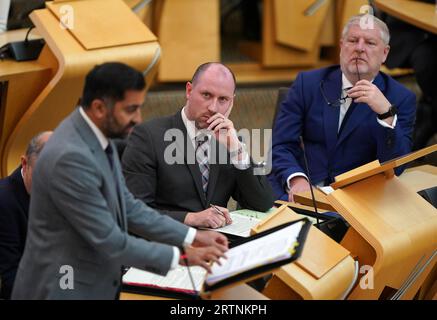 Neil Gray, Kabinettssekretär für Wirtschaft, faire Arbeit und Kultur, begleitet von Angus Robertson, Kabinettssekretär für Verfassung, Außenbeziehungen und Kultur, beobachten Schottlands ersten Minister Humza Yousaf bei den Fragen des First Minster’s (FMQs) im schottischen Parlament in Holyrood, Edinburgh. Bilddatum: Donnerstag, 14. September 2023. Stockfoto