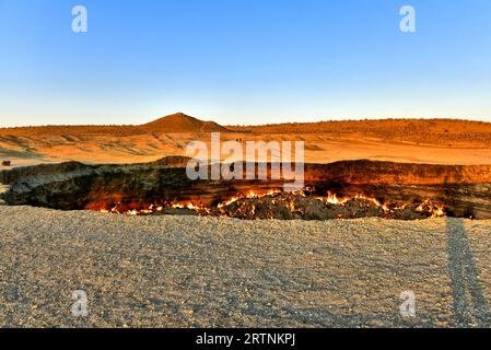 Wir haben die Nacht am Darvaza-Gaskrater zelten können, ein Foto von Erdgasfeuer, das im Krater brannte, bevor das Sonnenlicht die Macht übernahm Stockfoto