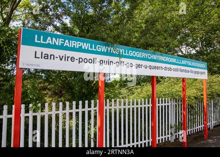 Das Schild auf dem Bahnsteig am Bahnhof Llanfairpwll im Dorf Llanfairpwllgwyngyll in Anglesey, Gwynedd, Wales. Das Dorf ist berühmt für mich Stockfoto