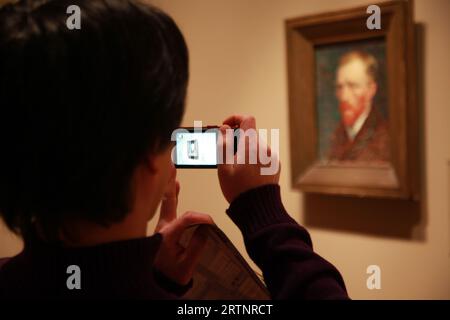 Der Besucher fotografiert ein Selbstporträt von Vincent van Gogh mit seinem Handy in einem Museum in Chicago, Ill Stockfoto