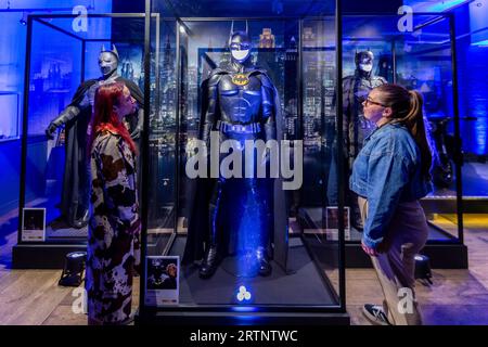 London, Großbritannien. 14. September 2023. Mitarbeiter sehen den Originalfilm Batman Batsuits, wie er von Christian Bale, Michael Keaton und Robert Pattinson getragen wurde, bei der Vorschau von Batman Unmasked bei 180 Piccadilly. Anlässlich des globalen Batman Day wird die legendäre Geschichte des Caped Crusaders durch seltene Comics gefeiert, von Batmans Anfängen bis zu seinem Auftritt in TV, Filmen, Videospielen und mehr. Die Show ist vom 15. Bis 17. September für die Öffentlichkeit zugänglich. Quelle: Stephen Chung / Alamy Live News Stockfoto