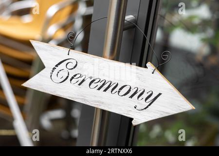 Hochzeitszeremonie Schild Pfeil aus Holz schwarzer Text auf weißem Hintergrund, der die Gäste zur Hochzeitszeremonie führt Stockfoto