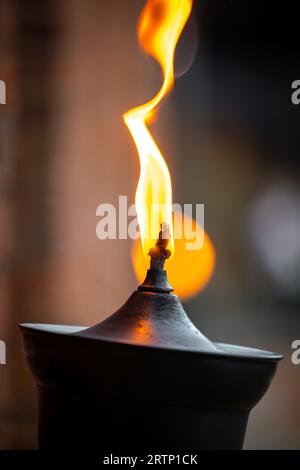 Große orangefarbene Flamme brennt auf der Öllampe schöne Nacht im Freien Stockfoto