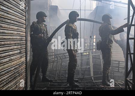 Die Armee von Bangladesch versucht, ein Feuer zu löschen, das am 14. September 2023 auf dem Mohammadpur Krishi-Markt in Dhaka, Bangladesch, ausbrach. Ein Brand, der am Mohammadpur Krishi-Markt in der Hauptstadt ausbrach, wurde nach fast sechs Stunden unter Kontrolle gebracht. Insgesamt 217 von 317 zugeteilten Geschäften wurden durch das Feuer beschädigt, das den Mohammadpur Krishi-Markt heute Morgen verwüstete, sagte ein Beamter der Dhaka North City Corporation. Mehrere hundert Händler auf dem Mohammadpur Krishi-Markt in Dhaka beklagen, dass sie bei dem massiven Brand heute Morgen Waren im Wert von mehreren CRS Taka verlieren. Stockfoto