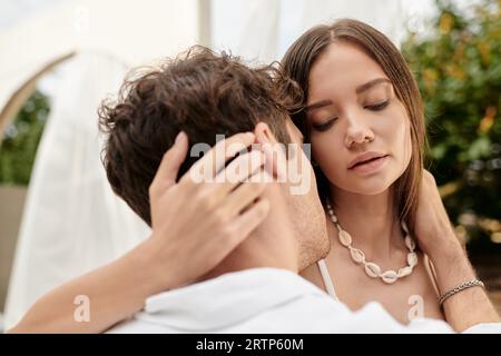 Porträt eines Mannes, der eine schöne Frau während eines romantischen Kurzurlaubs im Sommer umgibt, liebevolle Geste Stockfoto