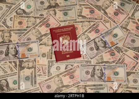 Ein ausländischer russischer Pass liegt auf verstreuten Dollarscheine Stockfoto