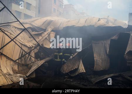 Dhaka, Bangladesch. September 2023. Feuerwehrleute löschen ein Feuer auf dem Mohammadpur-Markt, während Rauch aufsteigt. Ein massiver Brand hat Geschäfte auf dem Mohammadpur Krishi-Markt in Dhaka entkernt, Notfallpersonal der Armee, der Marine, des Schnelleinsatzbataillons, der Polizei von Bangladesch und der Grenzwache Bangladesch hat sich mit 17 Feuerwehren und Zivilverteidigungseinheiten zusammengeschlossen, um bei dem Ausbruch des Feuers zu helfen. Quelle: SOPA Images Limited/Alamy Live News Stockfoto