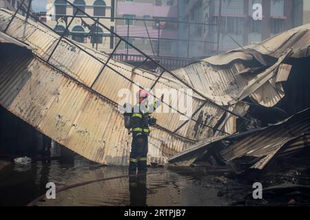 Dhaka, Bangladesch. September 2023. Feuerwehrleute löschen ein Feuer auf dem Mohammadpur-Markt, während Rauch aufsteigt. Ein massiver Brand hat Geschäfte auf dem Mohammadpur Krishi-Markt in Dhaka entkernt, Notfallpersonal der Armee, der Marine, des Schnelleinsatzbataillons, der Polizei von Bangladesch und der Grenzwache Bangladesch hat sich mit 17 Feuerwehren und Zivilverteidigungseinheiten zusammengeschlossen, um bei dem Ausbruch des Feuers zu helfen. (Foto: Sazzad Hossain/SOPA Images/SIPA USA) Credit: SIPA USA/Alamy Live News Stockfoto